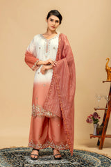 Woman wearing a peach and white traditional outfit with a matching dupatta against a beige background.