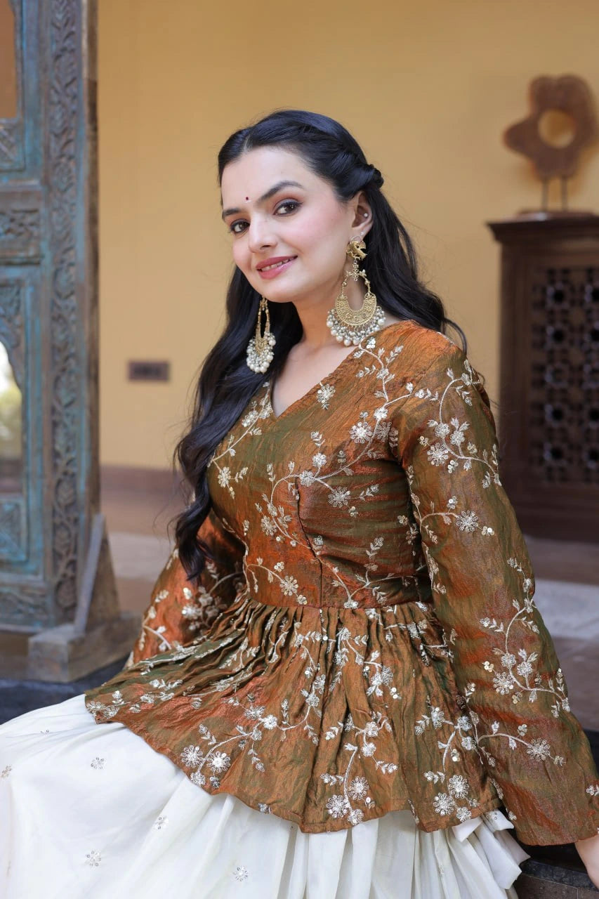 Woman in traditional attire with intricate design, indoors.