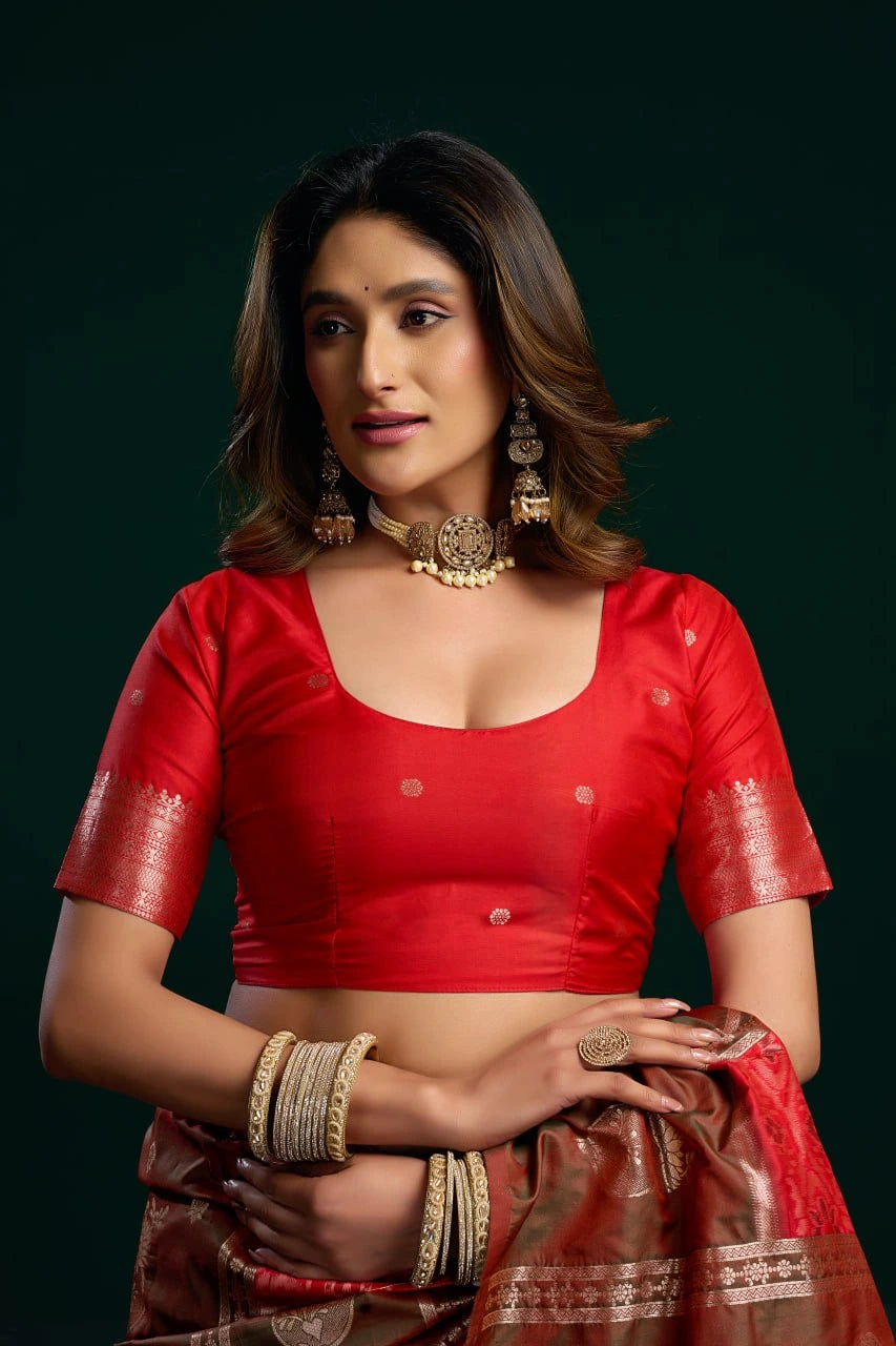 Woman in a red traditional outfit with jewelry against a dark background