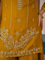 Close-up of a mustard yellow outfit with intricate gold embroidery.