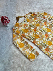Floral-patterned fabric on a textured surface with a small red flower decoration.