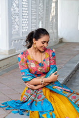 Stylish floral lehenga outfit featuring bold botanical prints, a coordinated blouse, and a bright blue silk dupatta, perfect for weddings and festive celebrations.