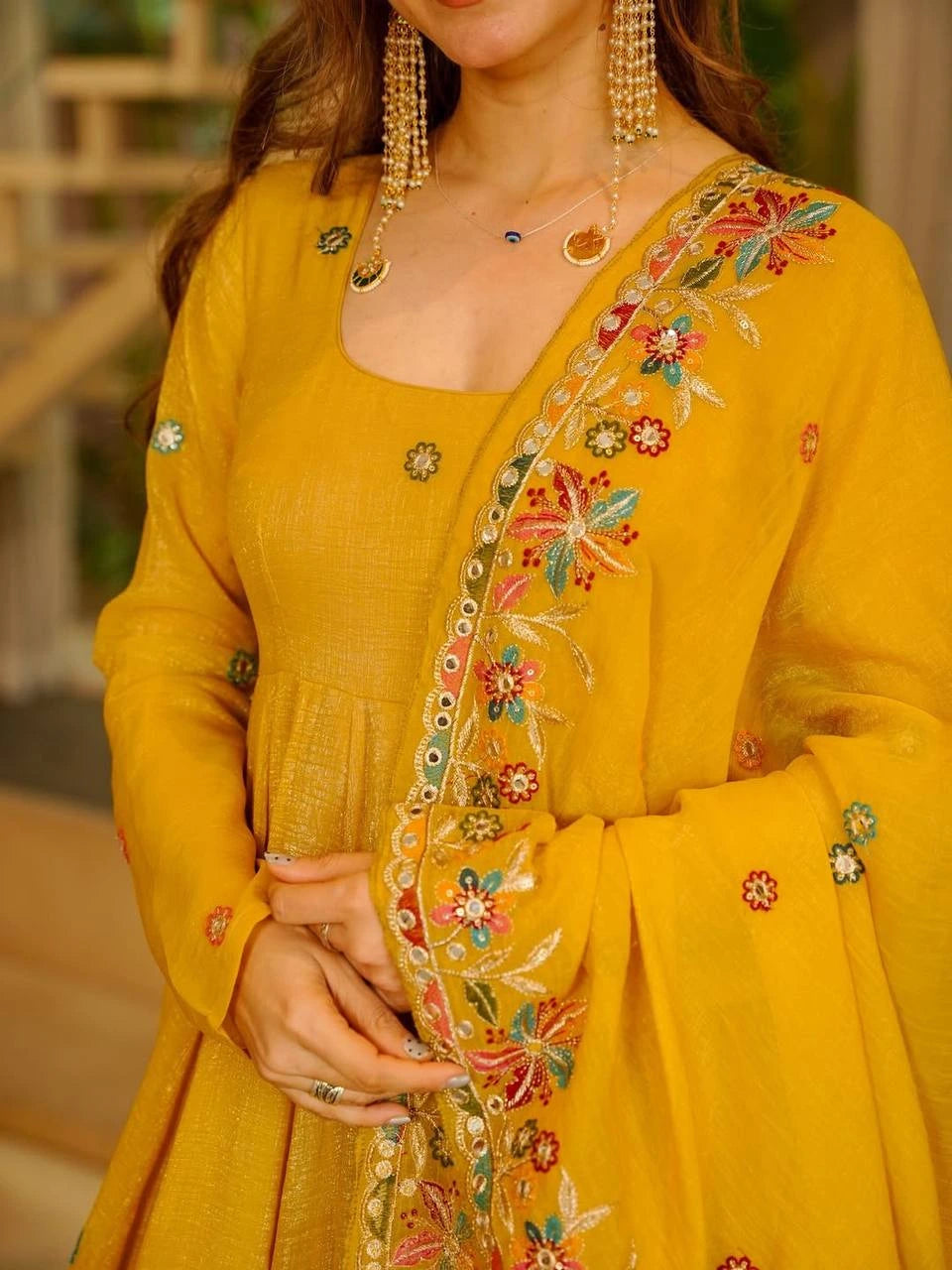 Yellow embroidered traditional outfit with intricate designs on a blurred background