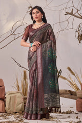 Woman wearing a traditional saree in a natural setting with plants and rocks.