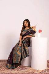 Woman in a traditional saree sitting on a white pedestal with a plain background