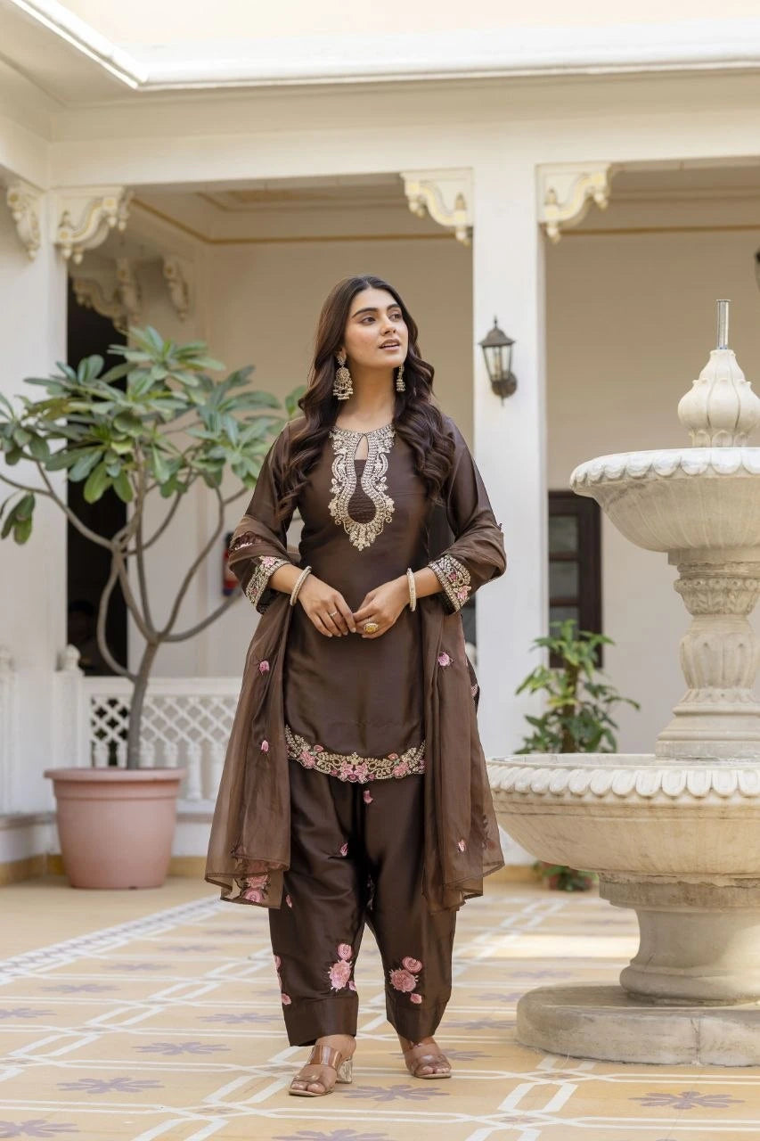 Woman in traditional brown outfit standing in a decorative indoor setting