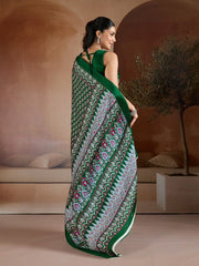 Woman wearing a green saree with a pattern in an indoor setting