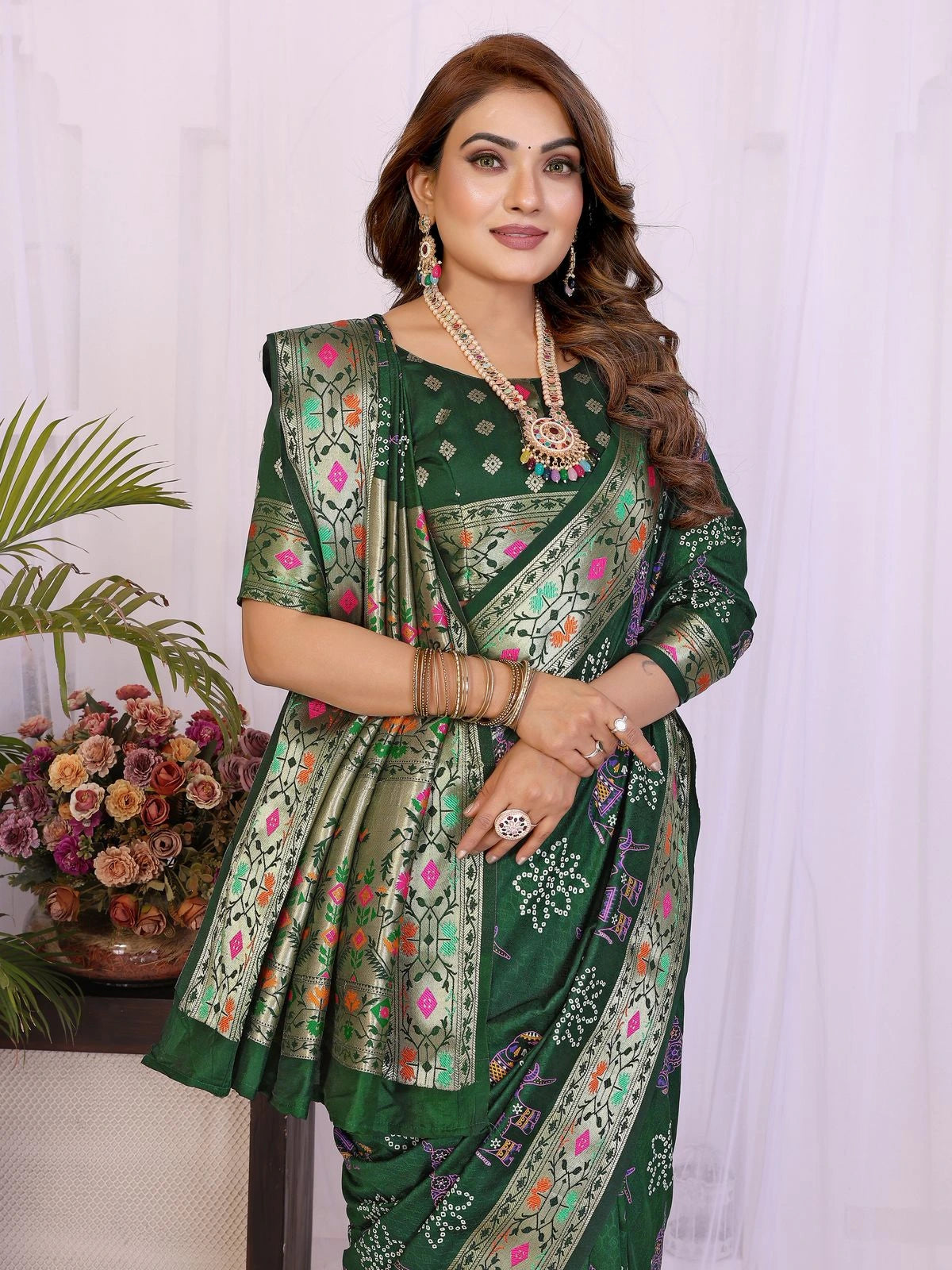 Woman wearing a green saree with floral patterns indoors