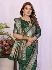Woman wearing a green saree with floral patterns indoors