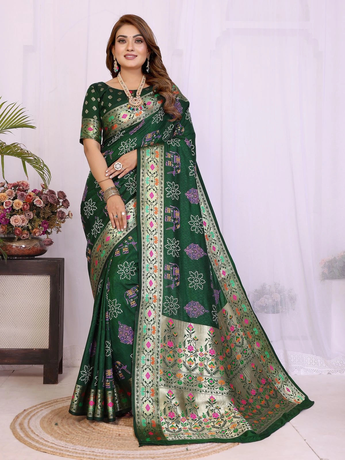 Woman wearing a green saree with floral patterns on a white background