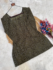 Black patterned dress on a hanger with flowers on a white background