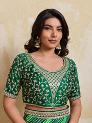 Woman wearing a green embroidered blouse against a beige background