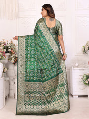 Woman holding a green and white patterned saree in a decorated room.