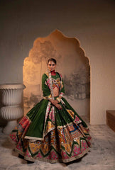 Woman in a traditional embroidered outfit standing in front of an ornate mirror.
