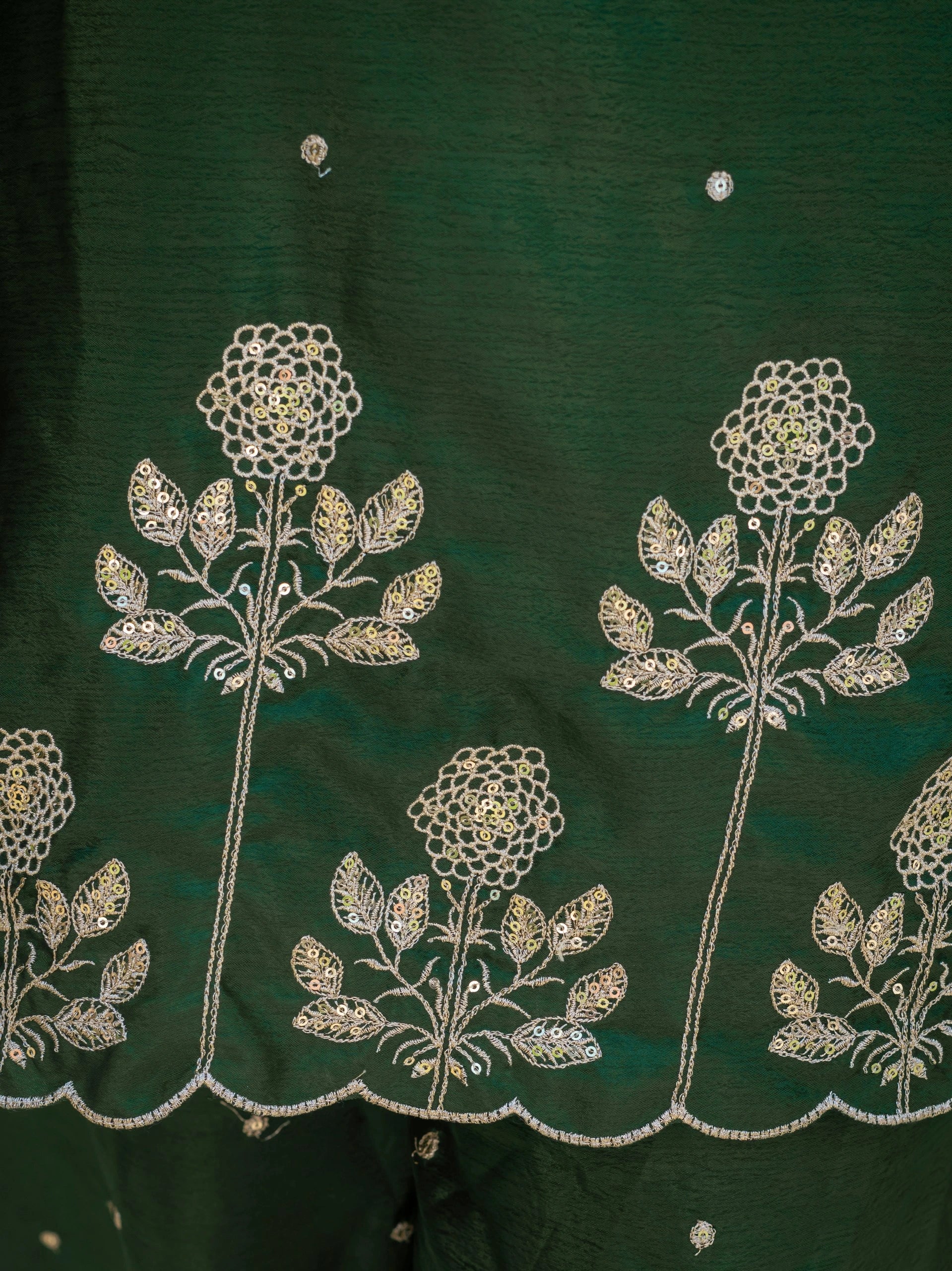 Green fabric with white floral embroidery