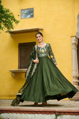 Woman in a green traditional outfit standing in front of a yellow building