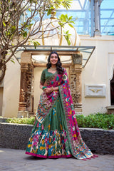 Woman in a colorful saree standing in an outdoor setting with architectural elements.
