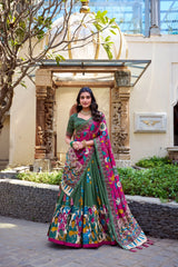Woman in a colorful saree standing outdoors with decorative elements in the background