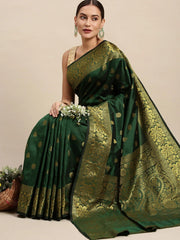 Woman wearing a green saree with gold patterns on a beige background