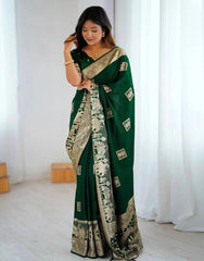 Woman wearing a green saree with white patterns in a minimalistic setting