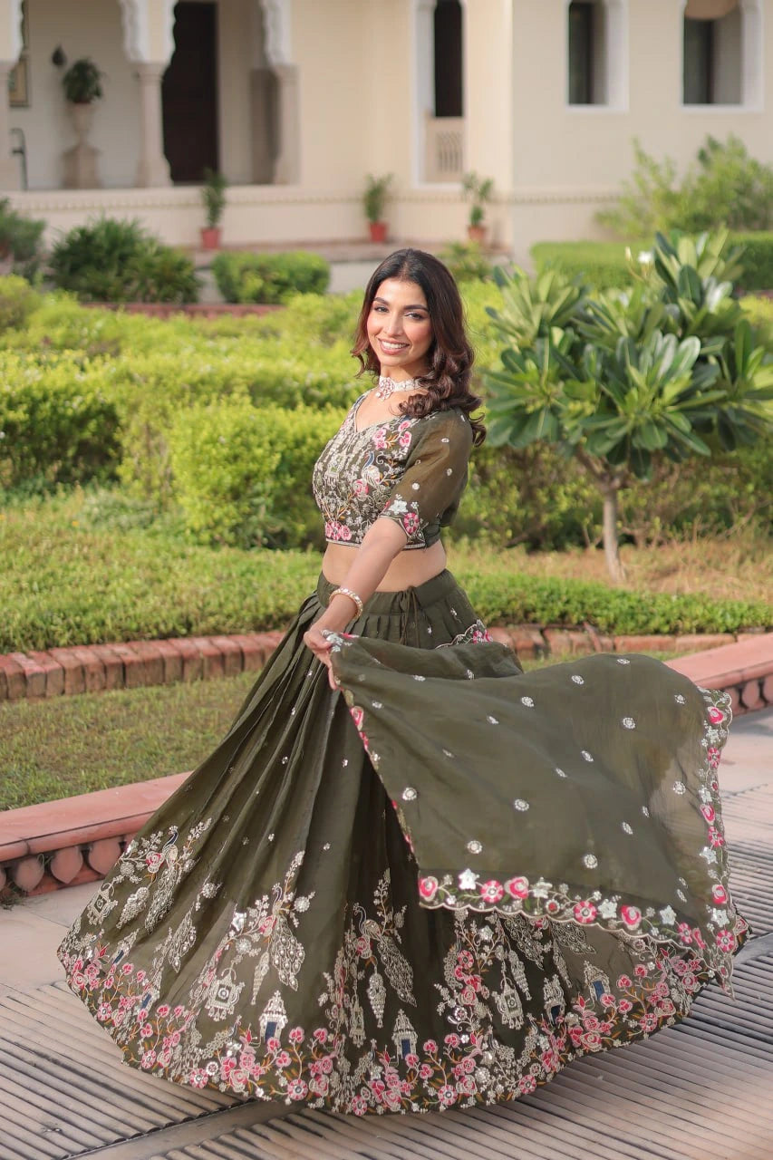 Woman in an embroidered traditional outfit standing outdoors with greenery in the background