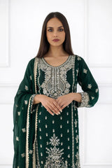 Woman wearing a green embroidered traditional outfit with a white background