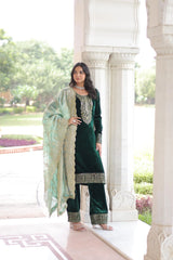 Traditional blue velvet suit with intricate gold detailing and a flowy dupatta, styled with statement jewelry in a palace-like backdrop.
