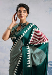 Woman wearing a green saree with geometric patterns against a light gray background
