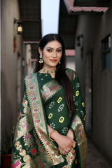 Woman wearing a traditional green embroidered saree with a blurred background
