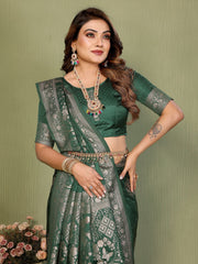 Woman wearing a green saree with intricate patterns against a green background