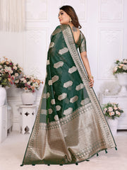Woman wearing a green and beige saree with floral decorations in the background