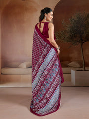 Woman wearing a maroon saree with a pattern in an indoor setting