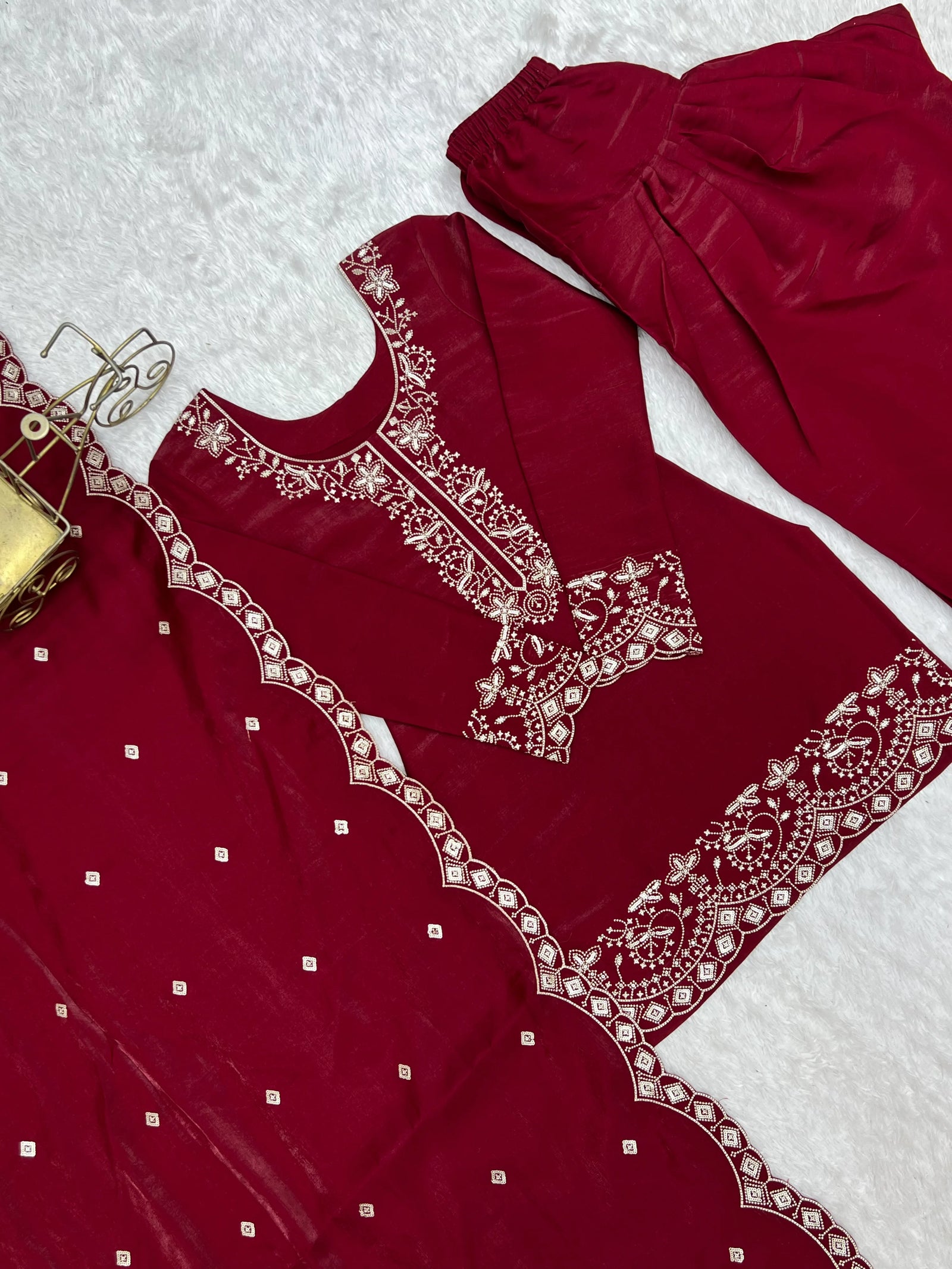 Red embroidered garment on a textured white surface