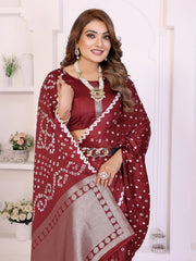 Woman wearing a maroon saree with white patterns in a well-lit room.