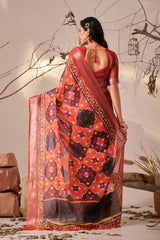 Woman wearing a traditional saree with intricate patterns in a decorative setting.