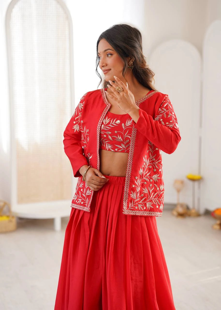 Woman wearing a red outfit with white embroidery in a minimal indoor setting