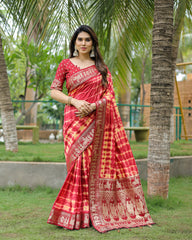 Woman in a red and white saree standing outdoors with palm trees in the background