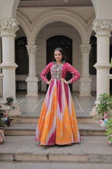 Woman in a colorful traditional outfit standing in an architectural setting with columns.