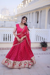 Woman in a red traditional outfit standing on a balcony with white columns and a plant in the background.