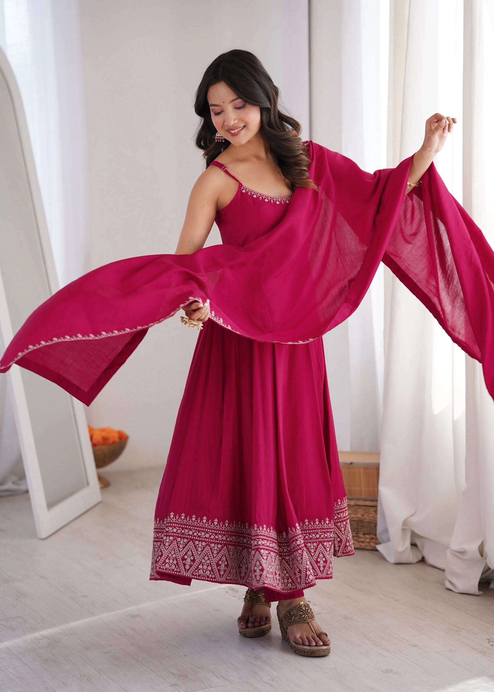 Woman in a red dress with a matching shawl in a bright room.