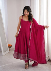 Woman wearing a pink traditional outfit with a matching dupatta in a bright room.