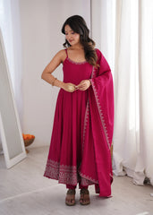 Woman wearing a pink traditional outfit with a matching dupatta indoors.