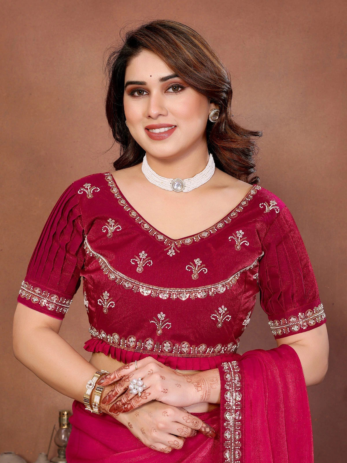 Woman wearing a red traditional outfit with intricate designs on a brown background
