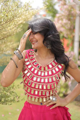 Elegant pink lehenga choli featuring a sleeveless mirror work blouse and a flared skirt with bold golden polka dot motifs.