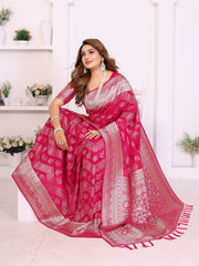 Woman wearing a pink saree with white patterns in a bright room.