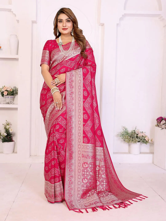 Woman wearing a pink saree with white patterns in a bright room.