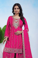 Woman wearing a pink embroidered traditional outfit with a white background