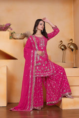 Woman in a pink traditional outfit with silver embroidery on a beige background