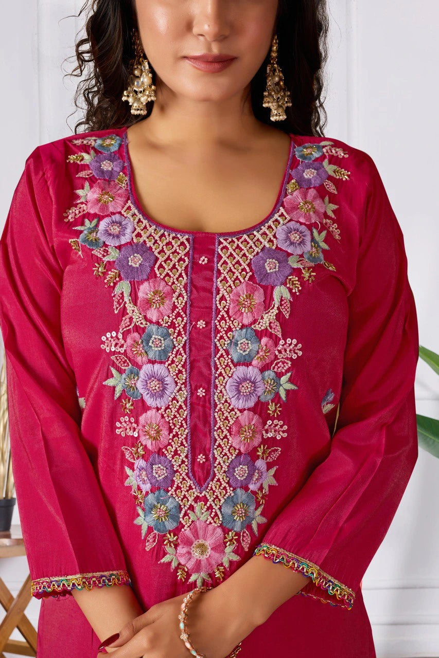 Woman wearing a pink embroidered traditional outfit with a white background