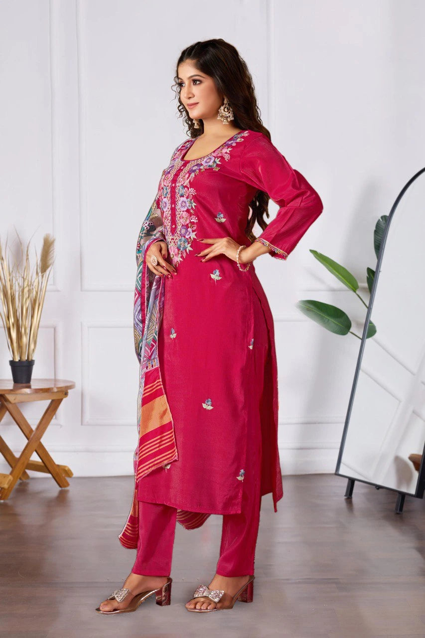 Woman wearing a pink traditional outfit with a colorful dupatta in a room.
